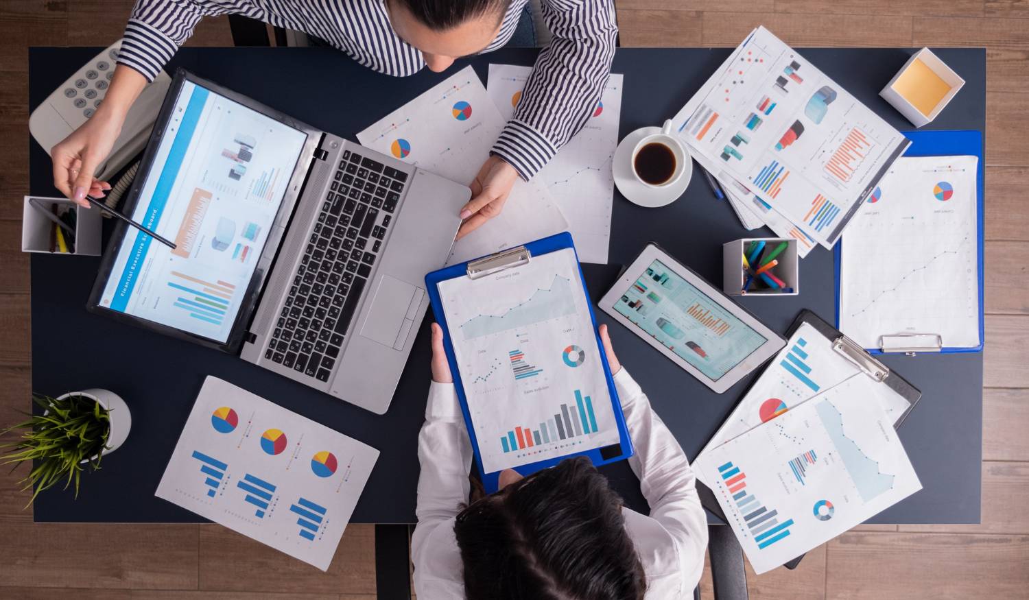 two people working at a desk with papers